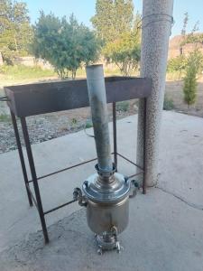a metal object with a smoke stack on a sidewalk at Istisu in Müqtǝdir