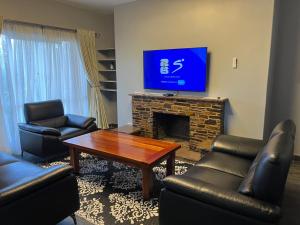 a living room with a tv and a fireplace at Nduna Legacy Apartment in Harare