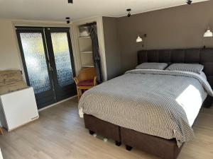 a bedroom with a large bed and a sliding glass door at Casa bosrust anloo in Anloo