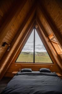 a bedroom with a large window in a attic at Cabana Stil A in Mărişel