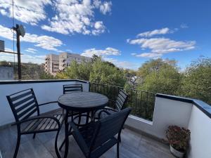 a patio with a table and chairs on a balcony at Nduna Legacy Apartment in Harare