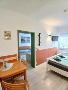 a living room with a table and a bed and a dining room at Pension Küfner in Markkleeberg