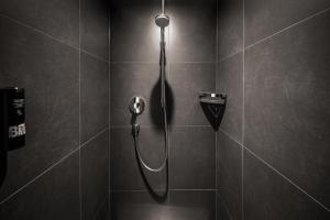 a shower with a shower head in a bathroom at LINDEMANN'S in Berlin +51 photos