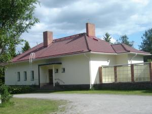 a large white house with a red roof at Huoneistohotelli Jokikeskus in Kemi