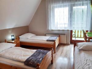 a bedroom with two beds and a window at Dom Wczasowy Kazik in Maniowy