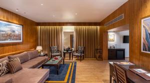 a living room with a couch and a table at Moksha Himalaya Spa Resort in Kasauli