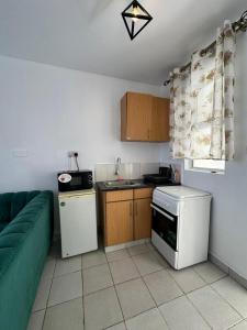 a kitchen with a couch and a kitchen with a stove at Ngong Road Luxe Studio in Nairobi