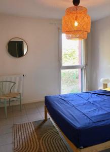 a bedroom with a blue bed and a window at Labenne beach apartment in Labenne