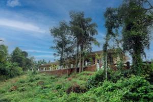 a house on the side of a hill with trees at Bekal Eden Resorts in Kāsaragod