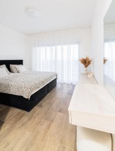 a white bedroom with a bed and a wooden floor at Villa Cardellino in Klis +14 photos