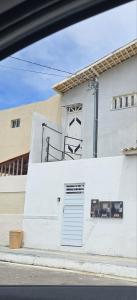 a white building with a door on the side of it at Studio Cinza em frente à praia in Aracaju