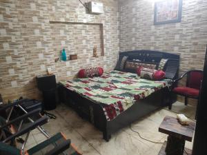a bedroom with a bed and a brick wall at Bali cottage in Jammu