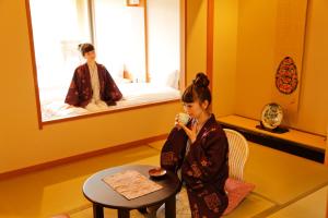 a young girl standing in a room with a table at Yumenoian Yuyake Koyake in Himeji