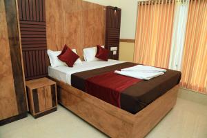 a bedroom with a large bed with red pillows at Bekal Eden Resorts in Kāsaragod