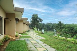 a walkway next to a house with a fence at Bekal Eden Resorts in Kāsaragod