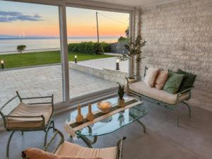 a living room with a view of the ocean at Aegean Horizon Seafront Luxury Villa Plomari Garden Level in Trýgonas