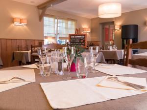 a table in a restaurant with glasses and napkins at Logis Auberge du Valburgeois in Sainte-Gauburge-Sainte-Colombe