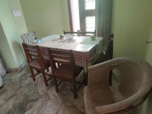 a dining room table with chairs and a table and a table and chairsuggest at Bali cottage in Jammu
