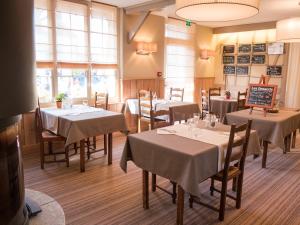 a dining room with tables with white tablecloths at Logis Auberge du Valburgeois in Sainte-Gauburge-Sainte-Colombe