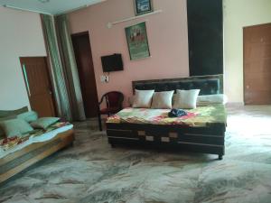 a bedroom with a bed and a chair in a room at Bali cottage in Jammu