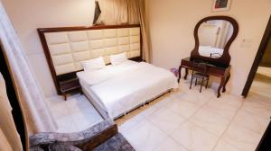 a bedroom with a bed and a mirror and a desk at شقق القنفذة بلس in Al Qunfudhah