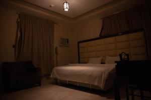 a bedroom with a large white bed in a room at شقق القنفذة بلس in Al Qunfudhah +2 photos