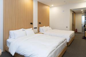 zwei Betten in einem Hotelzimmer mit weißer Bettwäsche in der Unterkunft Southernheal Hotel in Haenam + 40 Fotos