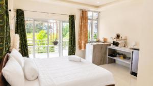 a white bedroom with a bed and a kitchen at Kopan House View Point by WildFlower in Thong Sala