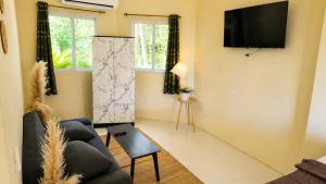 a living room with a couch and a tv on the wall at Kopan House View Point by WildFlower in Thong Sala
