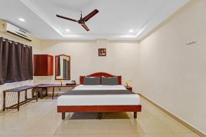 a bedroom with a bed and a ceiling fan at RG SUITES Mount Road in Chennai