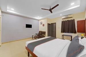 a bedroom with a bed with a ceiling fan at RG SUITES Mount Road in Chennai
