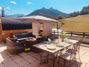 ein Tisch mit Stühlen und einem Sonnenschirm auf einer Terrasse in der Unterkunft Bambytwo in Ancelle