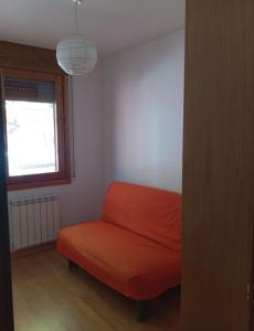 a red couch in a room with a window at Pis Relapieso in Vilaller +1 photo
