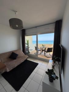 a bedroom with a view of the beach at Le TAHITI in Frontignan