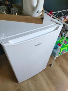a white refrigerator freezer sitting inside of a kitchen at chambre Chez sylvie in Allaire