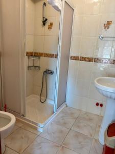 a bathroom with a shower and a toilet and a sink at Kalimerhaba Motel Restaurant in Gokceada Town