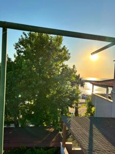 a view from the balcony of a house with a tree at Kalimerhaba Motel Restaurant in Gokceada Town
