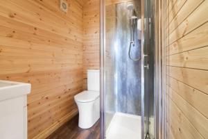 a wooden bathroom with a toilet and a shower at The Nest @The Outside Inn in Mountfield