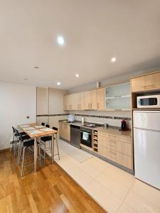 a kitchen with a table and a white refrigerator at Os limoeiros do cura in Foz
