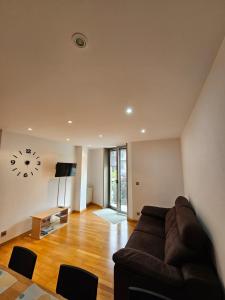 a living room with a couch and a clock on the wall at Os limoeiros do cura in Foz