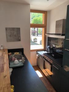 a kitchen with a black counter top and a sink at Furnished T2 apartment in Luchon