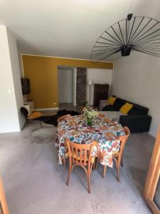 a living room with a table with chairs and a couch at Furnished T2 apartment in Luchon +7 photos