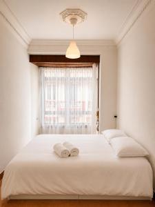 a bedroom with a white bed with two towels on it at Urban Hub in A Coruña