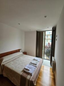 a bedroom with a bed and a large window at Os limoeiros do cura in Foz