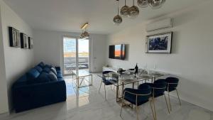 a living room with a table and a blue couch at Laguna Blu in Montepaone Lido