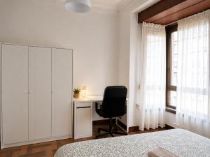 a bedroom with a desk and a chair next to a window at Urban Hub in A Coruña +3 photos