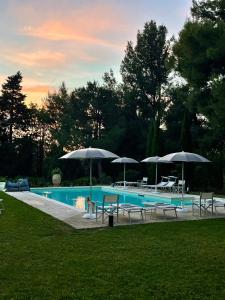 a pool with umbrellas and tables and chairs at Il Colle delle Terrazze in Fano