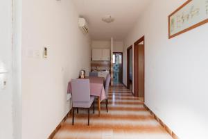 a kitchen and dining room with white walls and a table and chairs at Apartman Viola 1 in Ugljan
