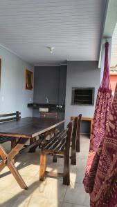 a living room with a wooden table and a hammock at House with pool Arroio do Sal in Arroio do Sal