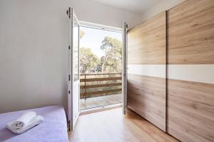 a bedroom with a sliding glass door with a window at Apartman Viola 1 in Ugljan